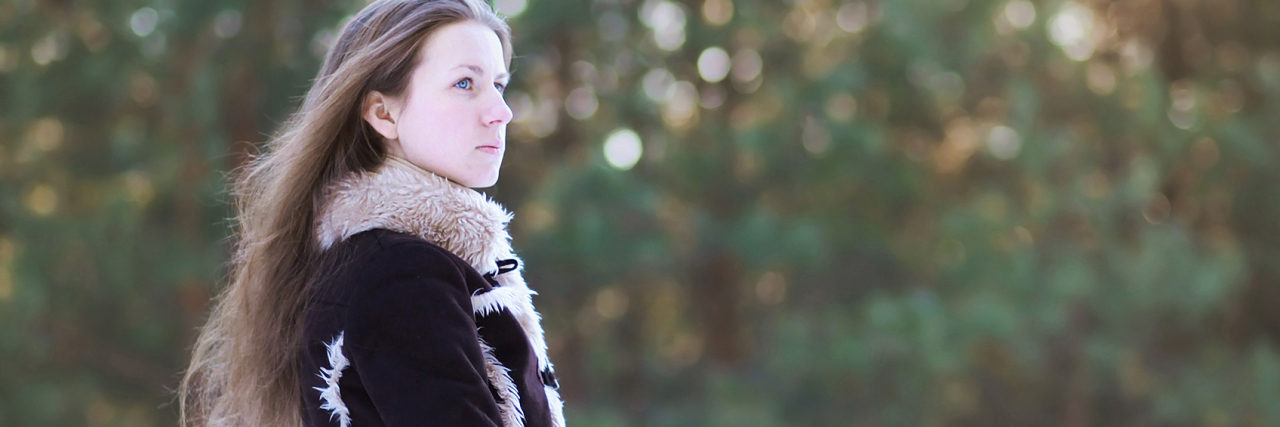 Why I Fear Recovering From My Depression young woman with long hair standing in forest looking into distance