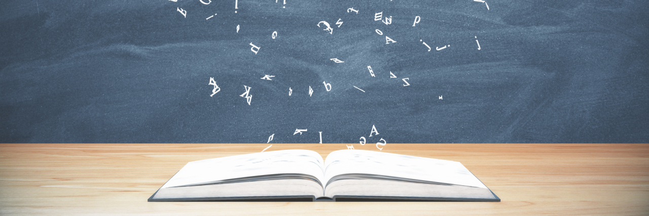 Why I'm Not Defined by My Chronic Illness A book laying on a table with letters flying above it.