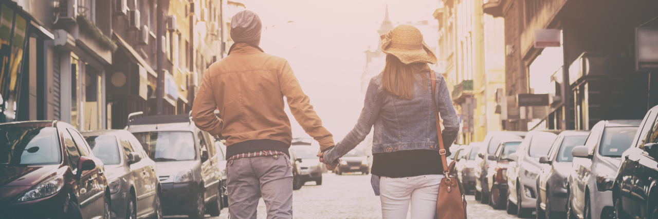 couple walking down a street and holding hands