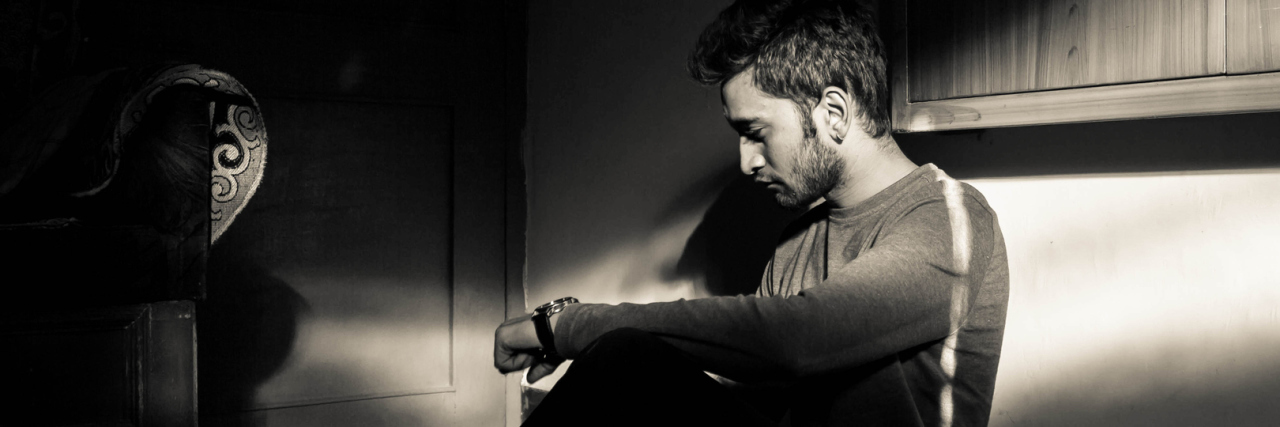 What to Remember During a Bipolar Depressive Episode young indian man sitting in dark room alone