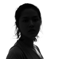 dark silhouette of a woman looking at the camera against a white background