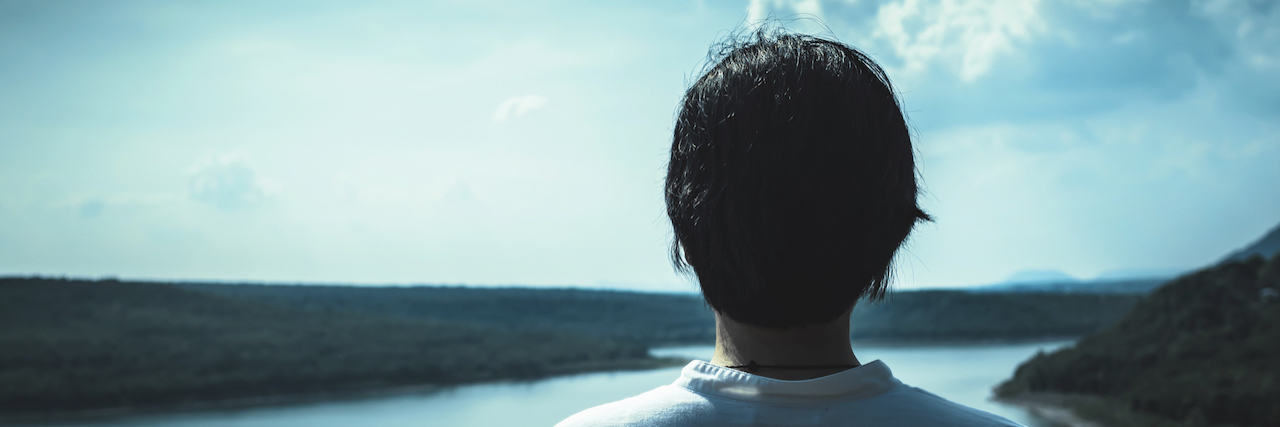 How to Help a Loved One With the 'Ugly' Parts of Mental Illness A woman looking out at a lake