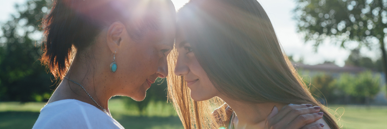 3 Things My Parents Did When I Was Feeling Suicidal as a Teen Cute pretty teen daughter with mature mother hugging in nature at sunset