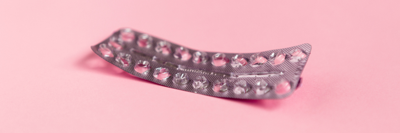 How Birth Control Debate Affects Me as Someone With Chronic Illness empty strip of birth control pills on a pink background