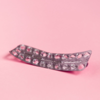 empty strip of birth control pills on a pink background