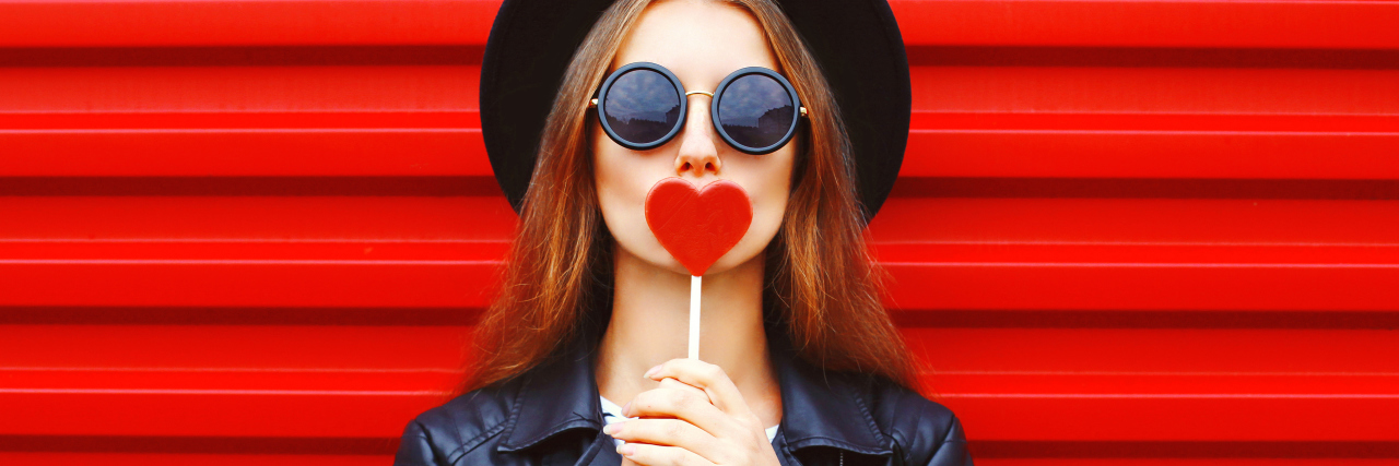 How to Love a Girl With Borderline Personality Disorder Fashion pretty young woman with red lollipop heart wearing black hat leather jacket over urban background