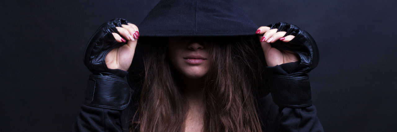 A woman wearing a black hoodie.