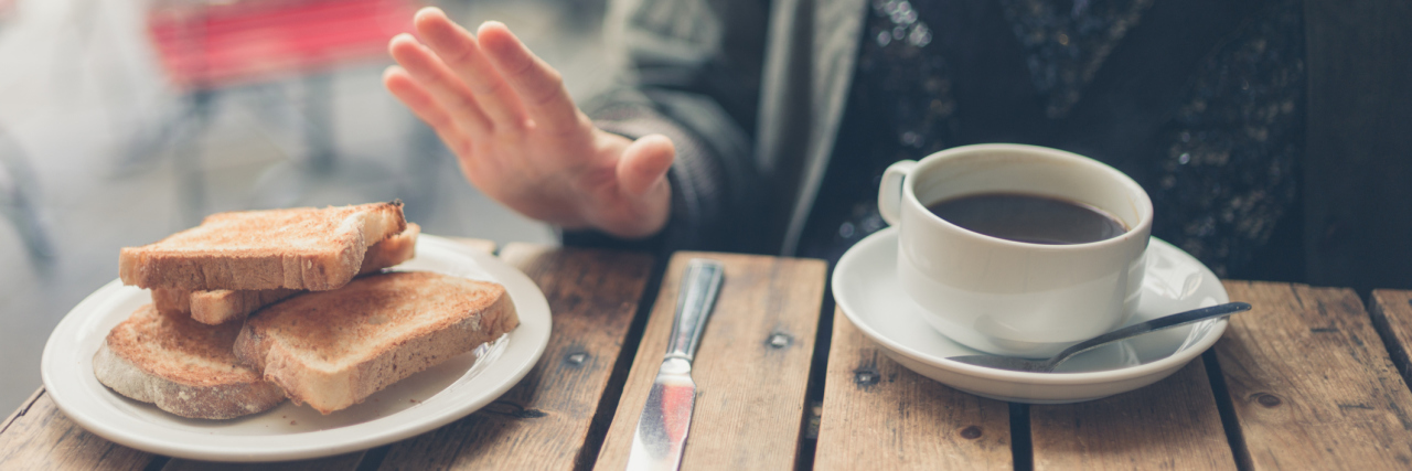 5 Things I've Learned While Living With Celiac Disease A woman at a table pushing away bread.