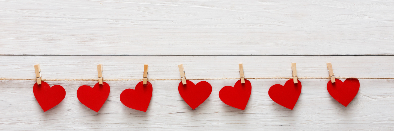 When Your Illness Makes You Forget Valentine's Day Paper hearts hanging on a string.