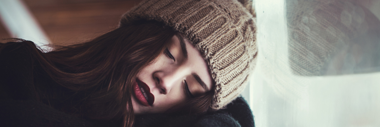 5 Frustrating Situations When You're Young and Have Chronic Pain A woman leaning against a window.