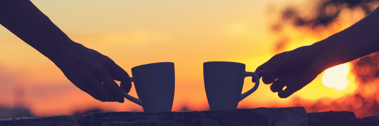 Friendship Between People With Disabilities Friends drinking coffee at sunset / sunrise.