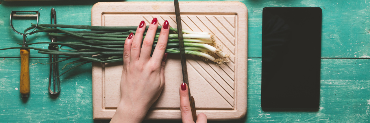 A female cutting green onions.