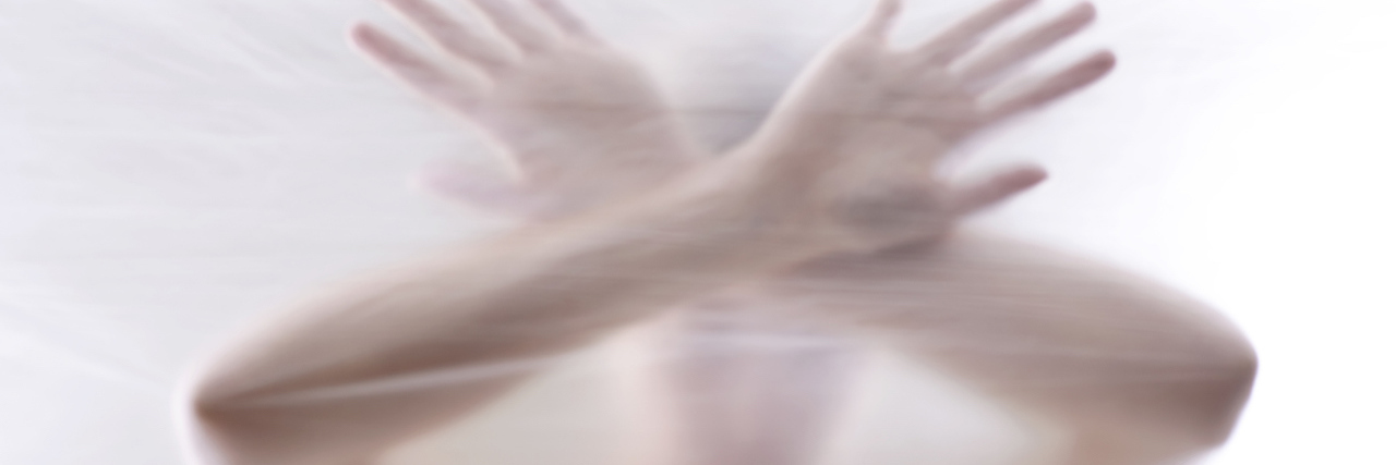 My Experience in Jail as a Person With a Mental Illness A woman behind a clear surface