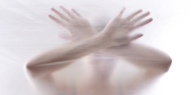 My Experience in Jail as a Person With a Mental Illness A woman behind a clear surface