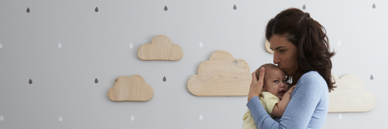 What to Do If You’re Feeling Anxious or Depressed After Having a Baby mother holding newborn baby in nursery