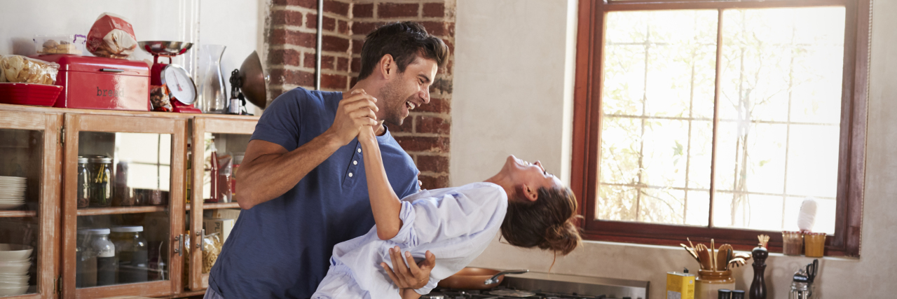 Happy couple dancing in kitchen in the morning