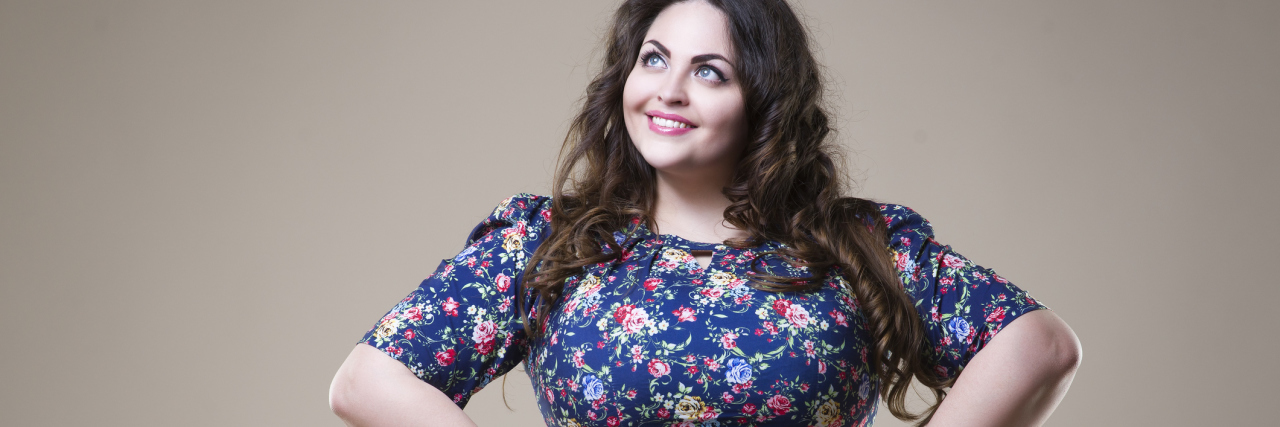 Embracing Chronic Illnesses Due to Body Positivity Movement woman smiling with her hands on her hips