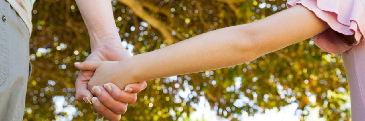 Embracing Acceptance When Parenting a Child With Angelman Syndrome Extreme close-up of a mother holding a hand of her daughter outdoors