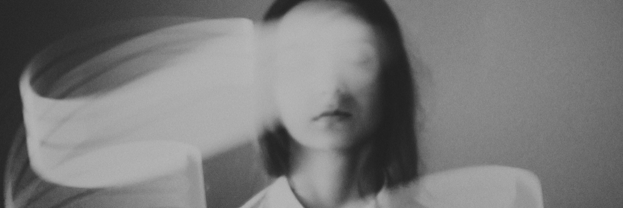 A woman with a white blur in front of her face