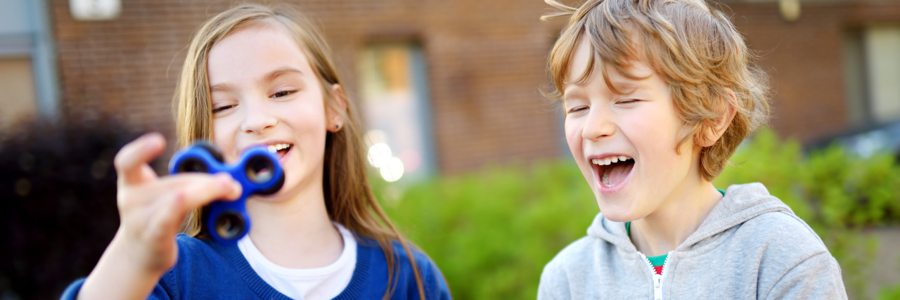 Neurodiversity and a Little Bit of Autism Friends playing with colorful fidget spinners.