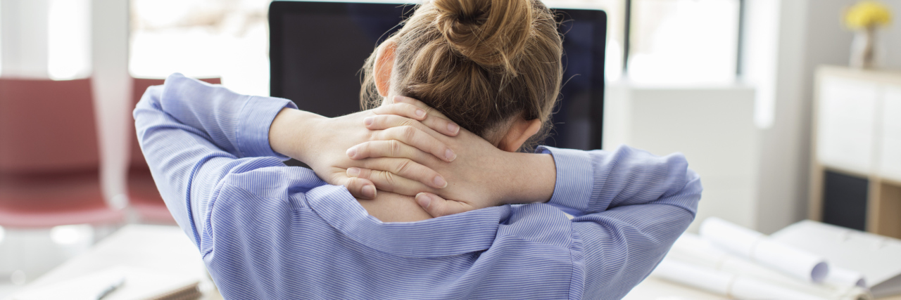 What Happened When I Returned to Work After a Mental Health Break woman in office tired or stressed with hands behind neck