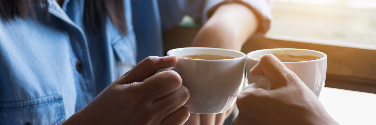 How My Best Friend Supports Me in Life With Chronic Illness two women holding cups of coffee and clinking their mugs together