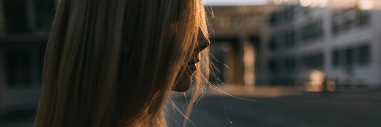 Questioning Your Invisible Pain When You Have Fibromyalgia woman with blonde hair standing outside with the sun behind her
