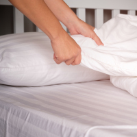 Changing sheets on a bed.