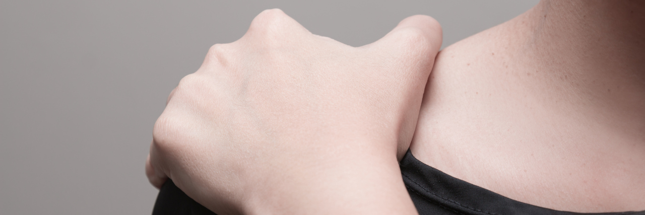 How My Physical Therapist Helped Me Change How I Talk About Pain A woman holding her shoulder.