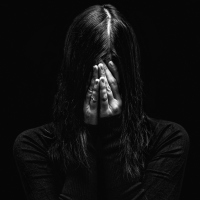 black and white photo of woman covering face with hands