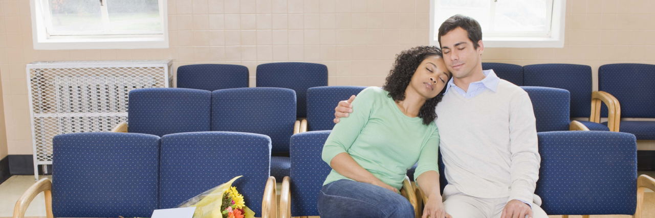 The Game I Play With My Husband While Waiting at Medical Appointments wife and husband sitting together in a waiting room