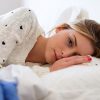 worried woman lying on bed thinking