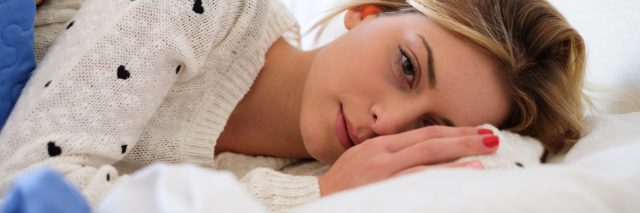 worried woman lying on bed thinking