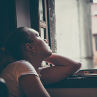 optimistic pensive woman looking out of window