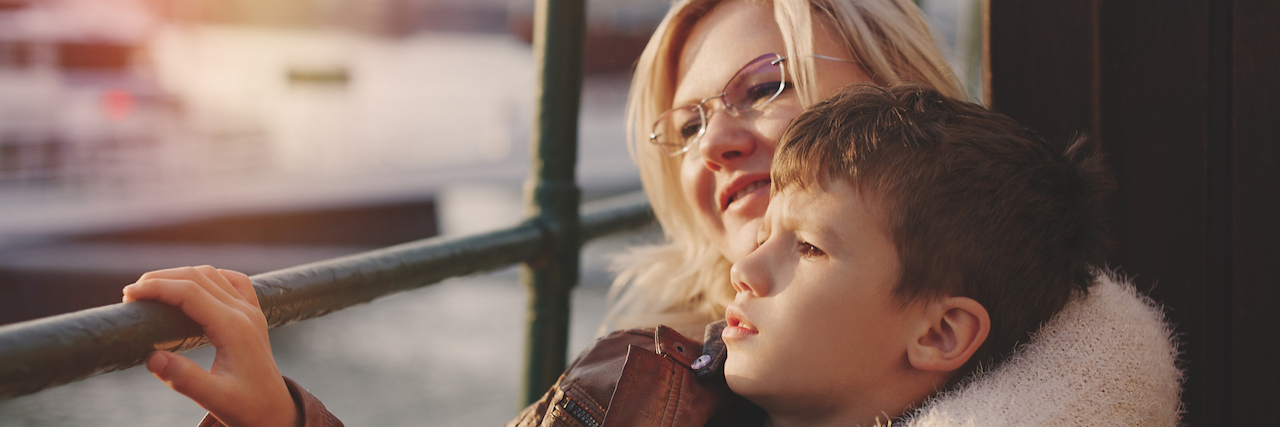 Parents: How to Handle Fear After a School Shooting A mother with her hands around her young son, looking out a window at the water.