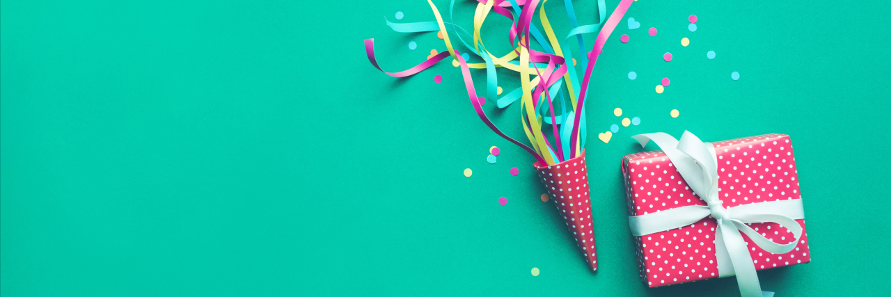 Why You Should Celebrate Your Illness Anniversaries and Milestones present, confetti and streamers against a turquoise background