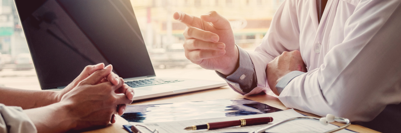 I'm the Reason Your Health Insurance Premiums Are So High Doctor and patient sitting and talking.