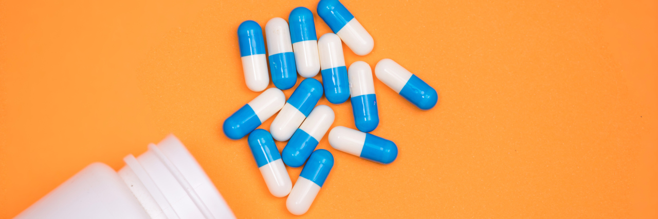 Fighting to Get Opioid Medication for Fibromyalgia, CFS, Chronic Pain prescription bottle with pills spilling out against an orange background