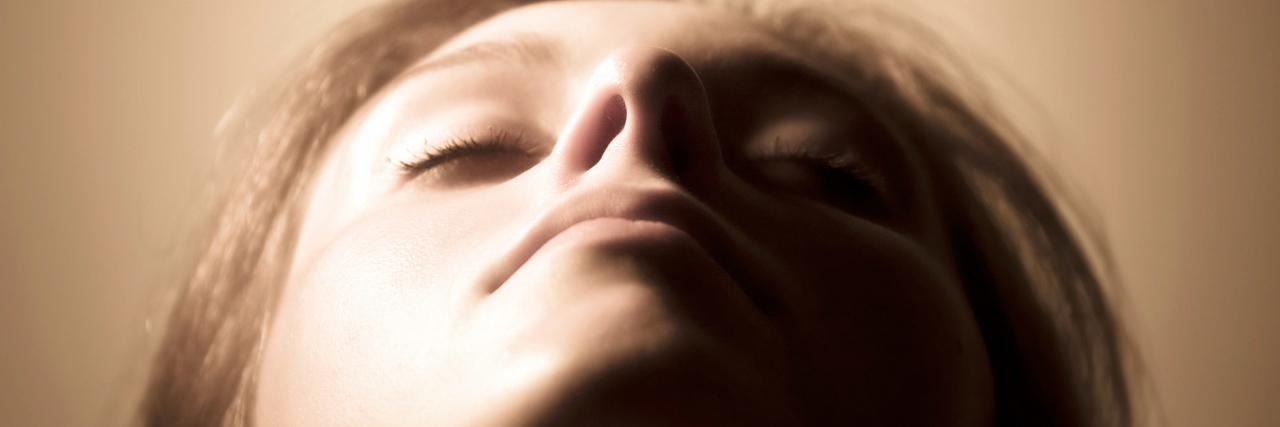 What It's Really Like to Live With Fibromyalgia woman with her head tilted back and eyes closed