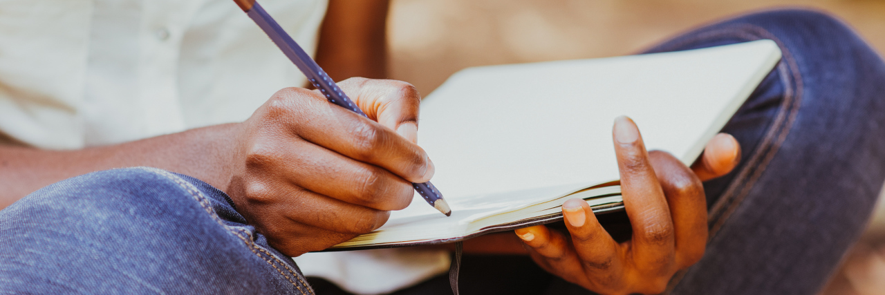 A Letter to Myself When I Was Diagnosed With Celiac Disease A woman writing in a notebook.