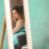 selective focus of woman's reflection in mirror against green wall
