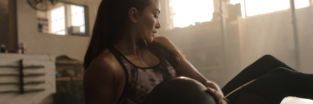 How CrossFit Helped Me See Myself as More Than Lyme Disease woman doing a crossfit workout with a medicine ball