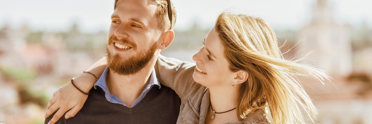 Encouraging Message From a Friend About Battling Fibromyalgia man and woman smiling outside in a city