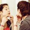 young woman cleaning pores or picking skin in front of mirror