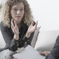 young woman talking to male therapist while gesturing with hands