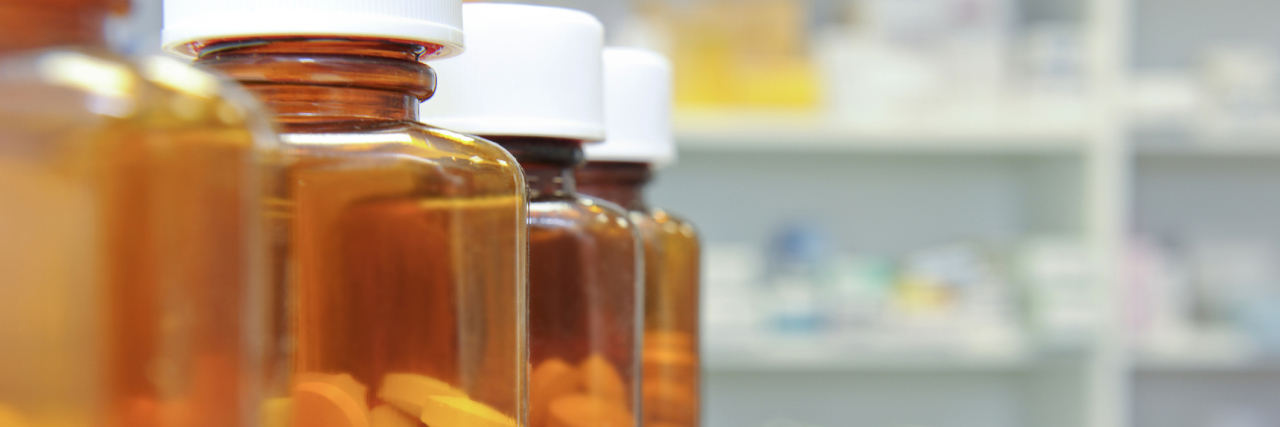 Medicare Proposes Cutting Opioids for Recipients row of bottles and pills on a chemists counter