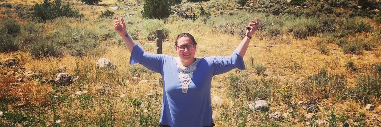 What It Means to Relinquish Control in Eating Disorder Recovery woman standing in desert with arms outstretched