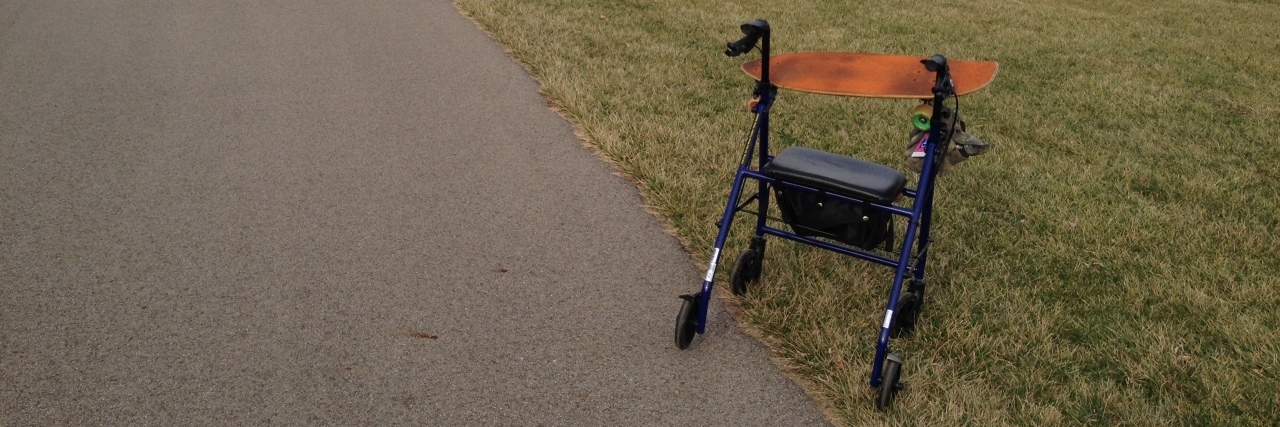 If You See Me at the Park With My Walker and Skateboard A photo of a walker and a skateboard in a park.