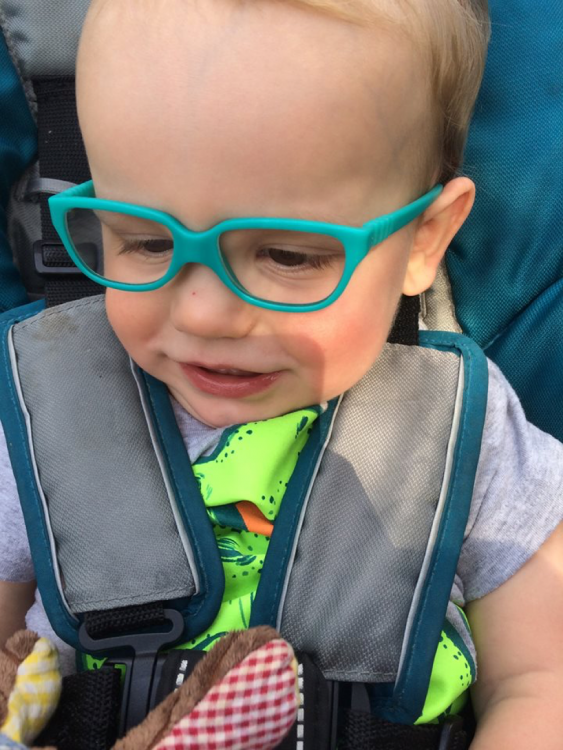 Lauren's son wearing glasses and smiling