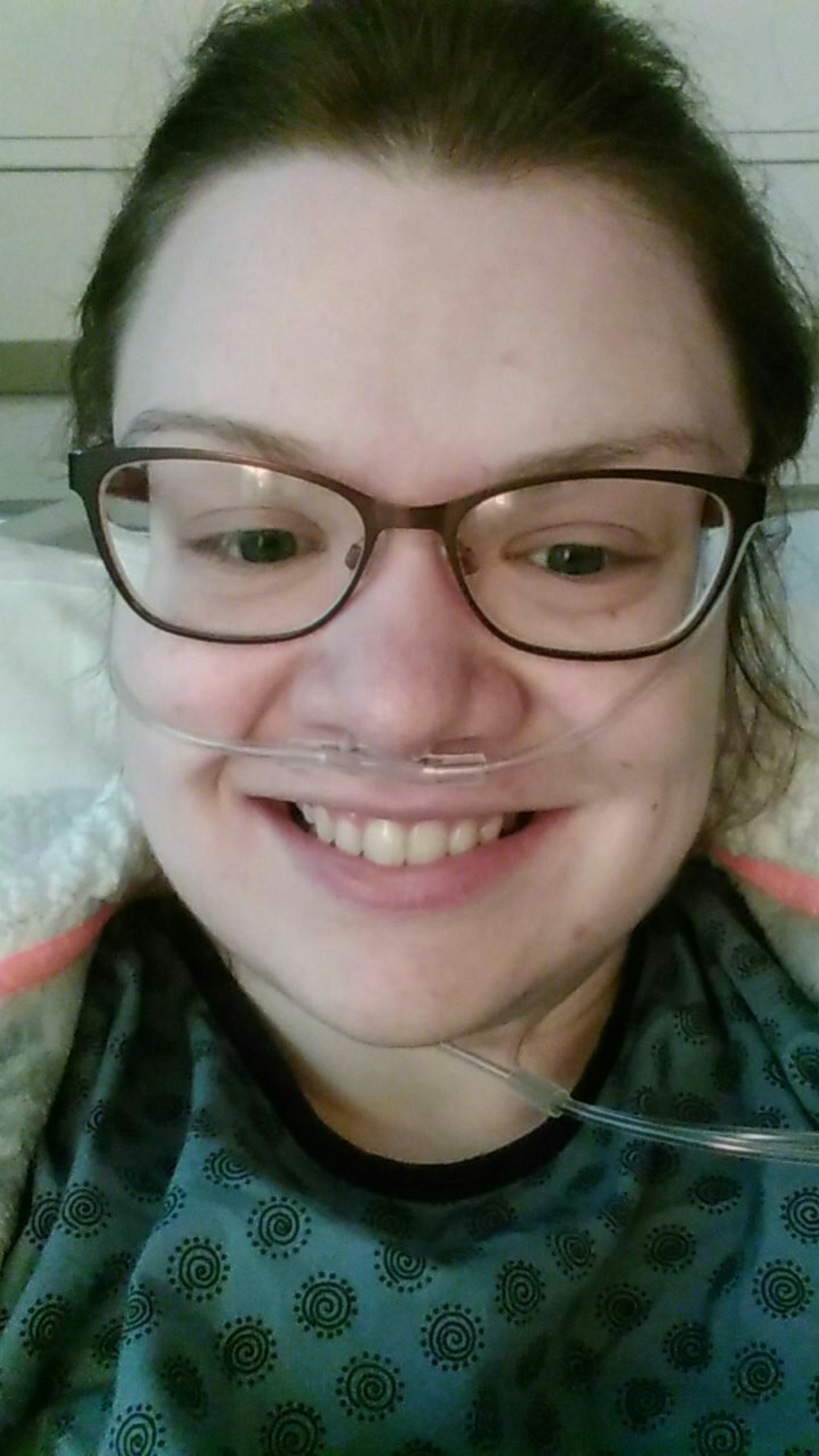 woman in the hospital wearing glasses and an oxygen tube in her nose